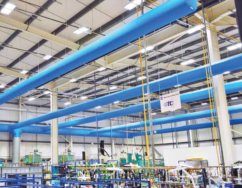 Fabric duct berwarna biru terpasang memanjang di langit langit sebuah pabrik