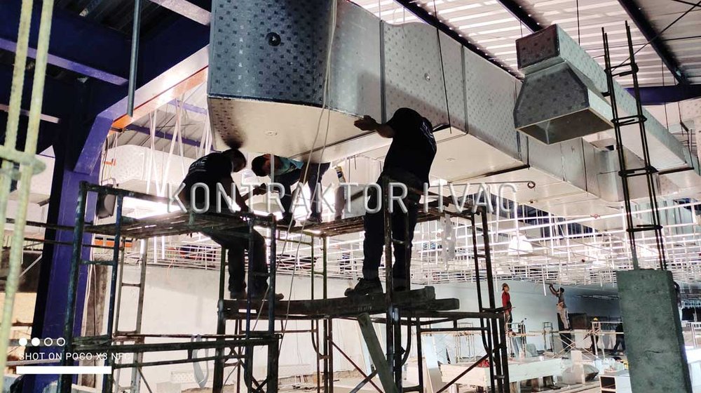 Teknisi memasang jalur ducting di ketinggian pada sebuah proyek