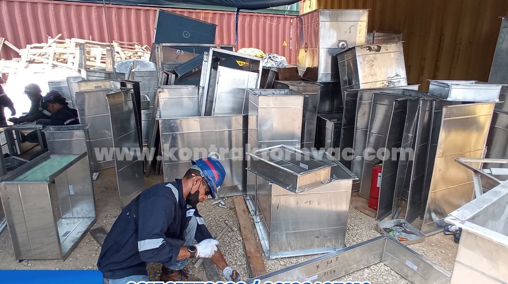 Pekerja memabrikasi potongan ducting di bengkel