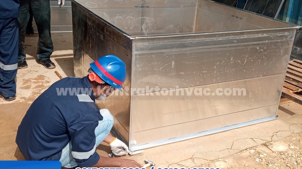 Pekerja menyelesaikan sambungan pada bodi ducting di bengkel